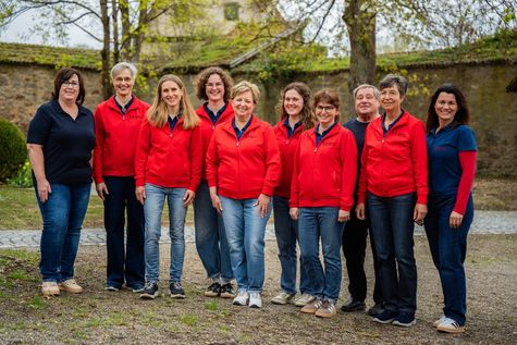 Das Bild zeigt eine Gruppe von Apothekenmitarbeiterinnen und -mitarbeitern in einem Park.